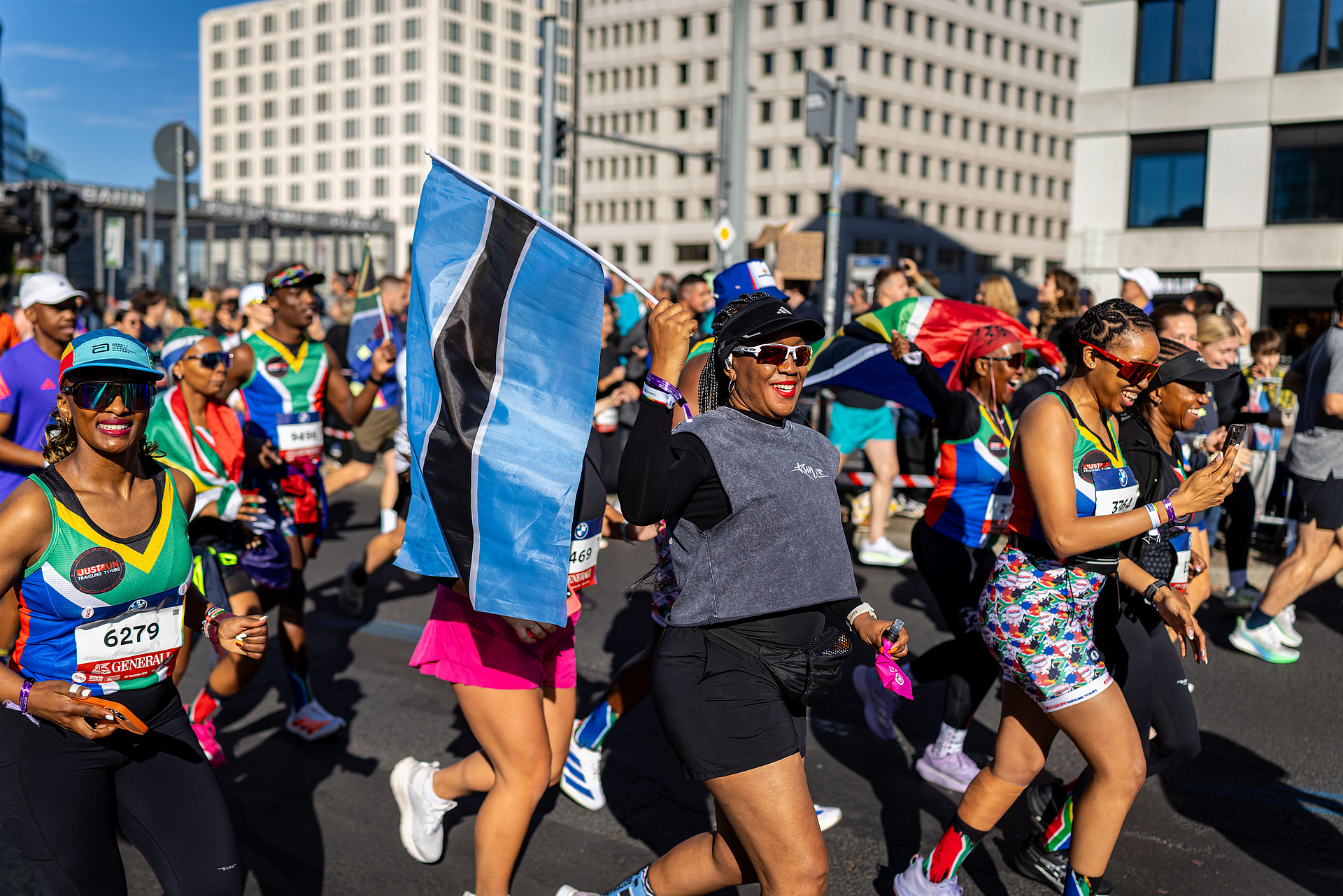 Cheerful runners holding various flags.