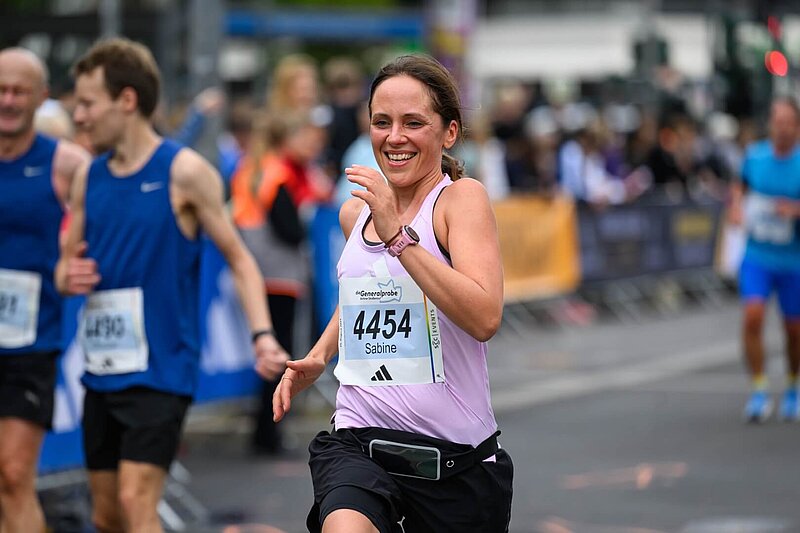Woman running with a broad smile at the event “Die Generalprobe”