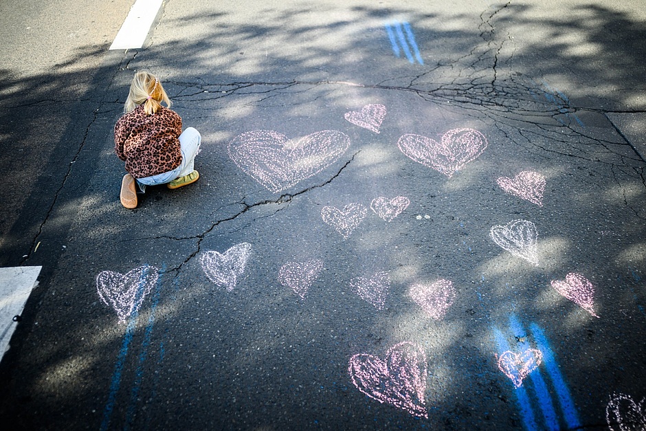 A small child draws hearts with chalk on the course, between two markers on the ideal line.