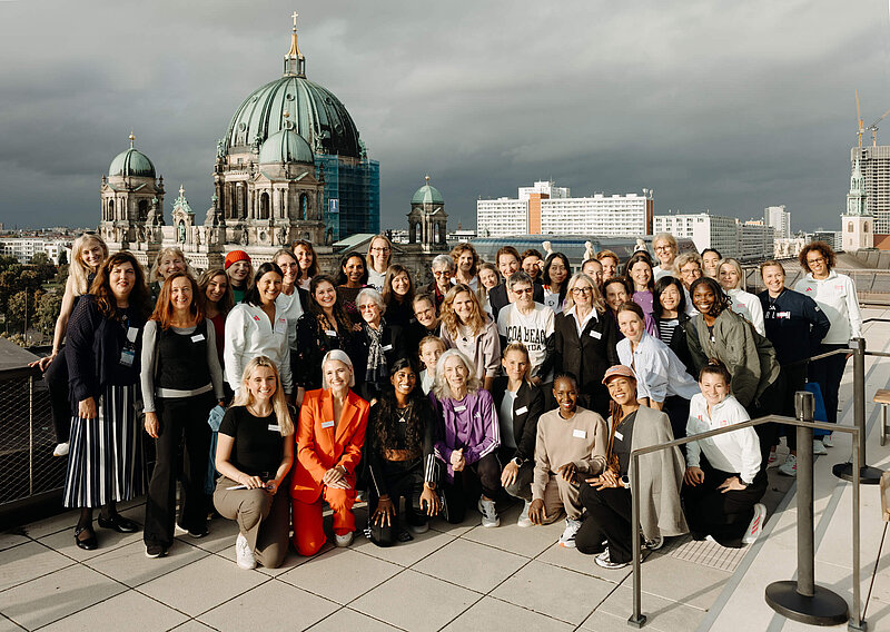 Group photo of international female runners; Berlin Cathedral in the background.