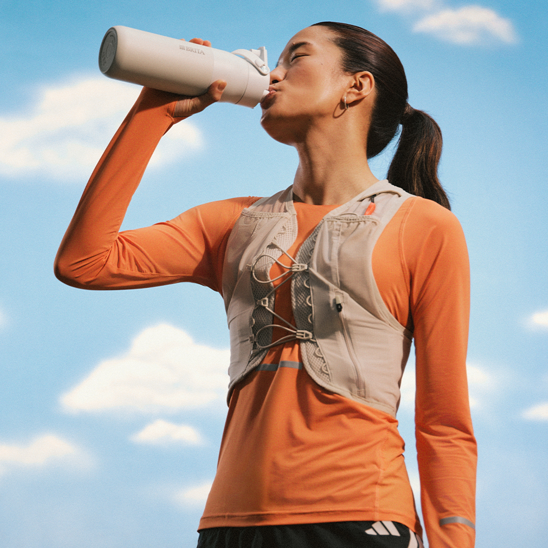 Sportlerin trinkt genüsslich aus ihrer Sportflasche.